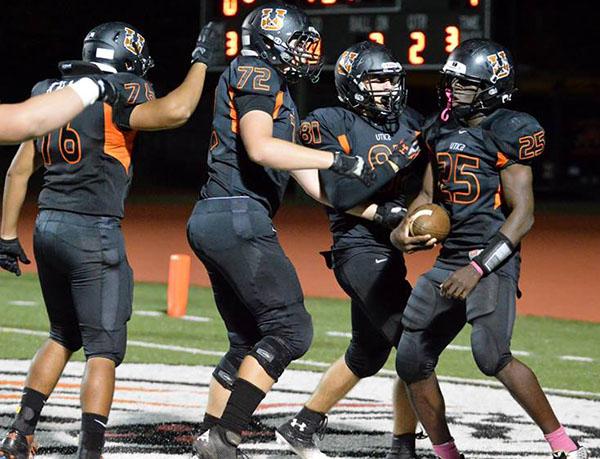 After scoring a touchdown to take the lead  in last year's game against Henry Ford II High School, Kumehnnu Gwilly celebrates with the offensive line, who gave him space to score. "I love playing at the quarterback position," Gwilly said. "It confuses the defense into whether I'm going to run the ball or pass the ball."