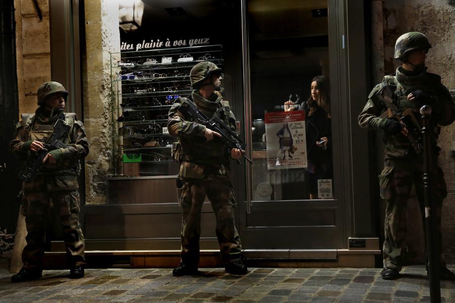 Parisian soldiers stand watch outside of a store after the terrorist attack.