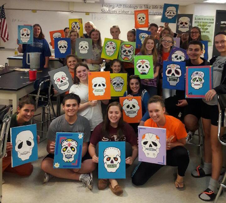 Hispanic Honor Society members display their artwork after painting with a twist.
