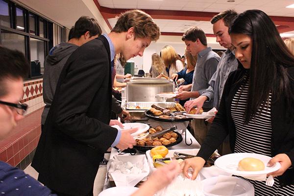 In the cafeteria, new National Honor Society members enjoy breakfast as part of the tapping ceremony.