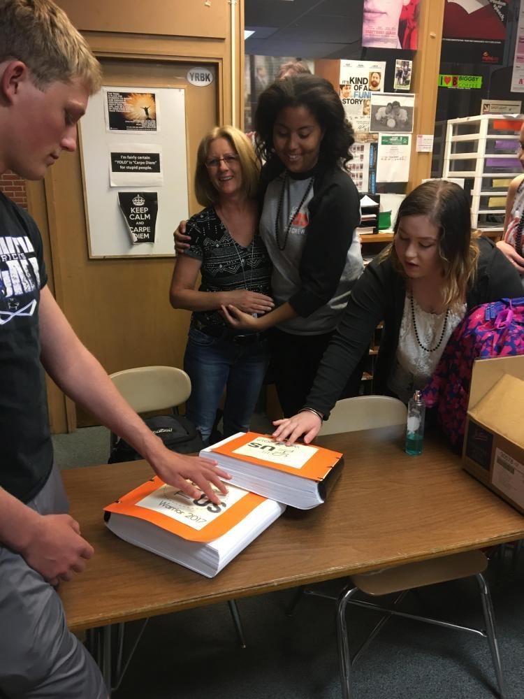 Paraprofessional Suzanne Cubitt delivers the braille books to the yearbook staff, and students were excited to touch the three-dimension version of their cover graphic.