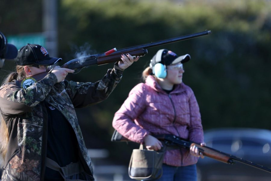 At the North Macomb Sportsmen’s Club in Washington, sophomore Annie Grzeszczak takes down a clay target while sophomore Shelby Remeselnik waits for her next shot.