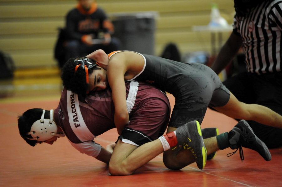 Sophomore Tahami Waris pins down a wrestler from Ford High school during a match.