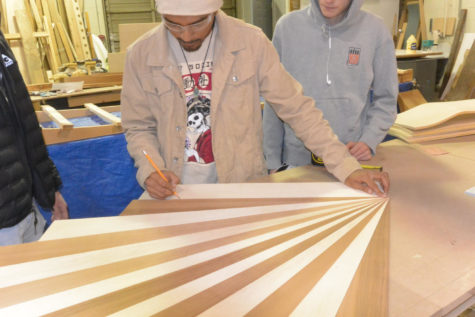 In the woodworking lab, senior Johnathen Green lays out a design for a paddleboard.