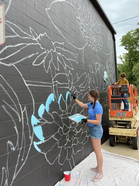 Junior Sarah Monticciolo assisted David Junior High art teacher Gail Borowski with the mural, which was a popular attraction for homecoming photos this year.
