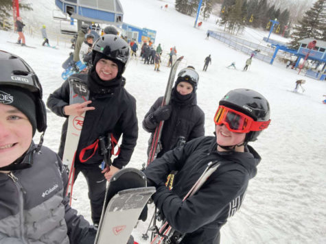 Juniors Alec Prange, Caleb Muraszewski, Ryan Mondello, and Brian Pogasic take a group photo at the top of a ski mountain. 