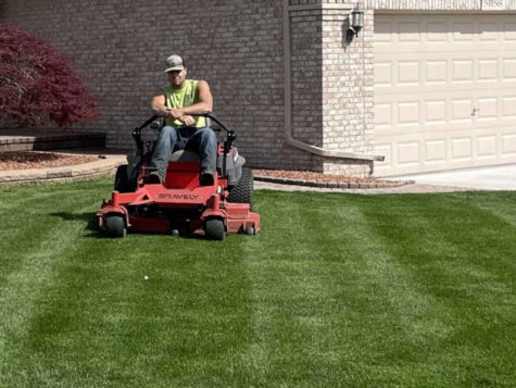 Senior Frank Valenti, owner of Macomb Lawn Service, mows a yard.