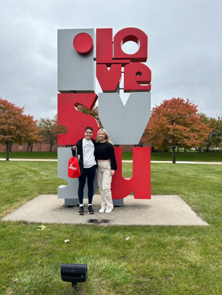 Gracie Weatherington and Loriana Mannino standing next to SVSU Love sculpture. 