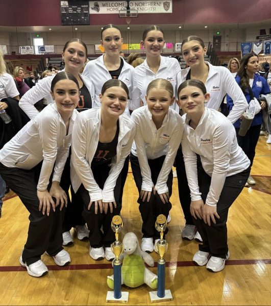 The Jv dance team posed in front of their trophy after placing 4th in pom, and 6th in Jaz in the Great Lakes Dance Competition.