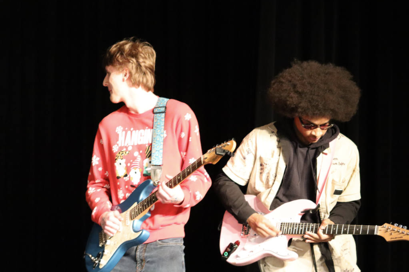  Junior Collins Harris and Junior Jonathan McCabe play “Perhaps Vampires Is a Bit Strong But...” By Arctic Monkeys on the electric guitar.