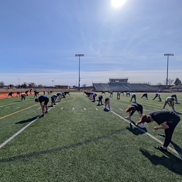 Photo of the Day #106!
Yesterday, track veterans led the sprinters in a hamstring stretch for their warm up routine at their second practice of the year.