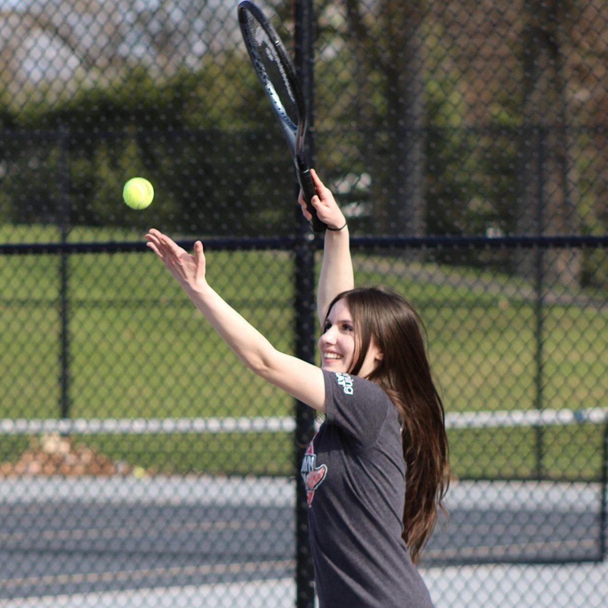 Sophomore Lauren Riley setting up the serve after finishing the match with Warren Mott High School for extra practice to hone in on her skills on April 13.